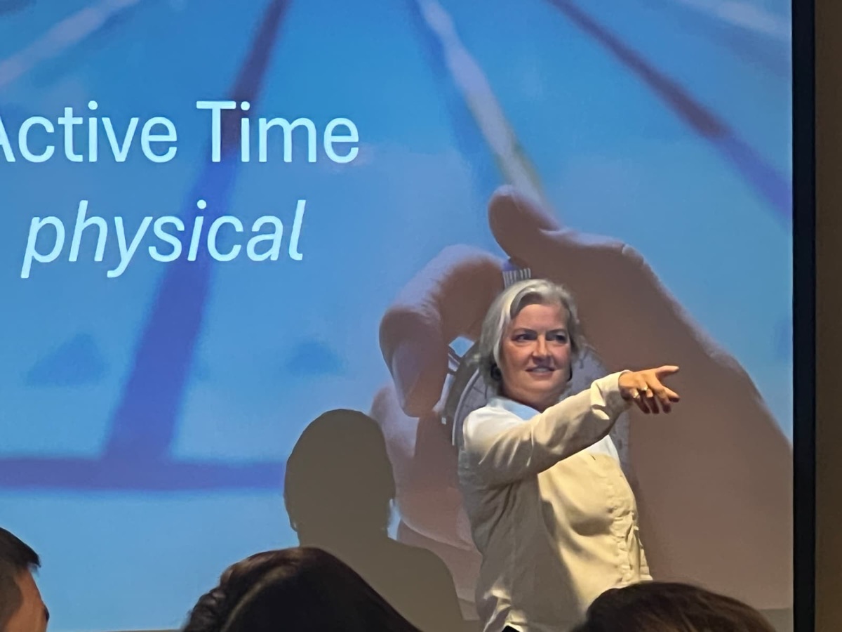 Cathryn presenting to an audience on stage