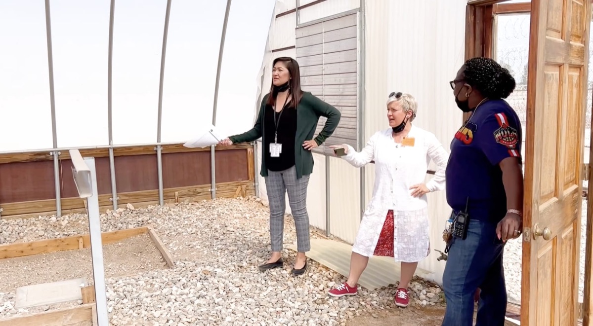 Cathryn walking through a greenhouse with facility staff during an on-site assessment
